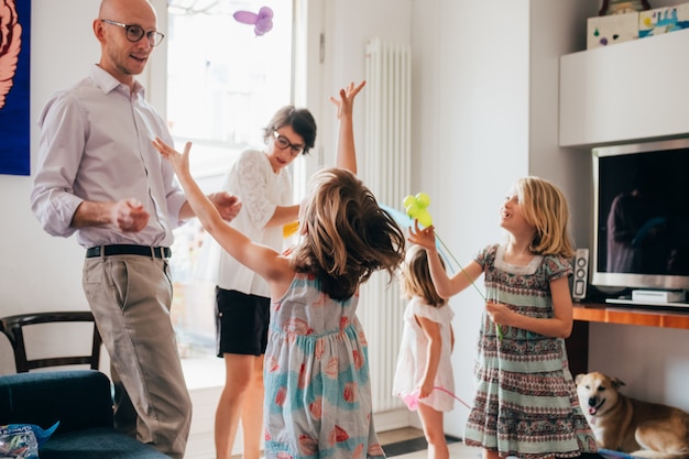 Beautiful family indoor playing with balloon toys