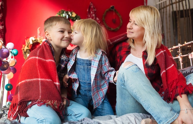 Beautiful family in New Year's clothes, hugging, having fun in the house