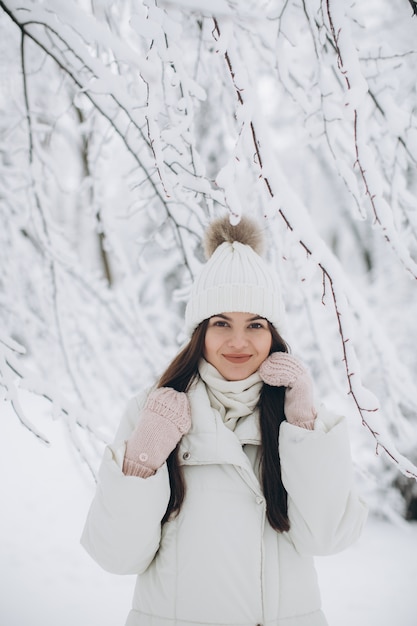 A beautiful and fashion woman in white warm clothing walking in snowy weather.