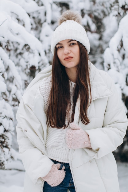 A beautiful and fashion woman in white warm clothing walking in snowy weather.