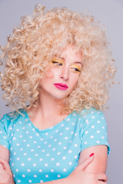 Photo beautiful fashionable blonde girl in retro style with voluminous curly hairstyle