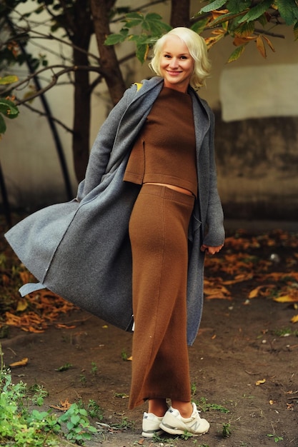 Beautiful fashionable woman standing on the city street Autumn day