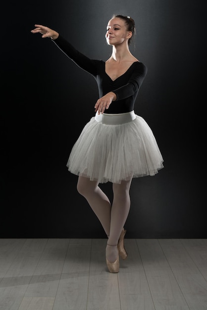 Beautiful Female Ballet Dancer On A Black Background  Ballerina Is Wearing A Tutu And Pointe Shoes