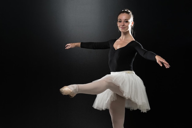 Beautiful Female Ballet Dancer On A Black Background  Ballerina Is Wearing A Tutu And Pointe Shoes