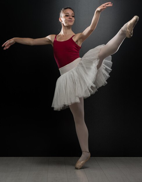 Beautiful Female Ballet Dancer On A Black Background  Ballerina Is Wearing A Tutu And Pointe Shoes