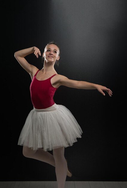 Beautiful Female Ballet Dancer On A Black Background  Ballerina Is Wearing A Tutu And Pointe Shoes