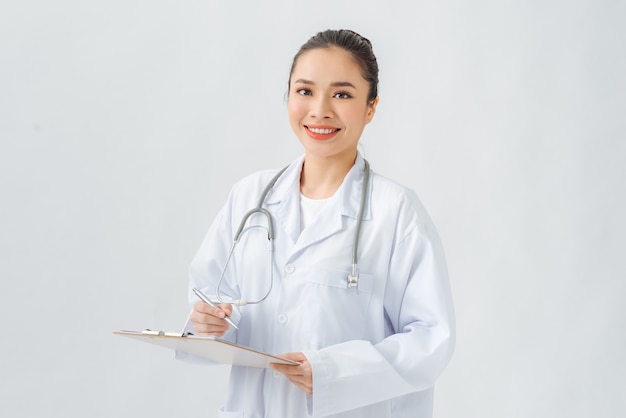 Beautiful female doctor holding clipboard smiling isolated on white background.