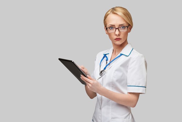 beautiful female doctor holding tablet pc pad isolated