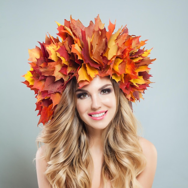 Beautiful female face Happy woman with autumn leaves crown makeup and blonde curly hairstyle