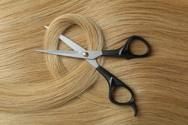 Beautiful female hair with scissors close up