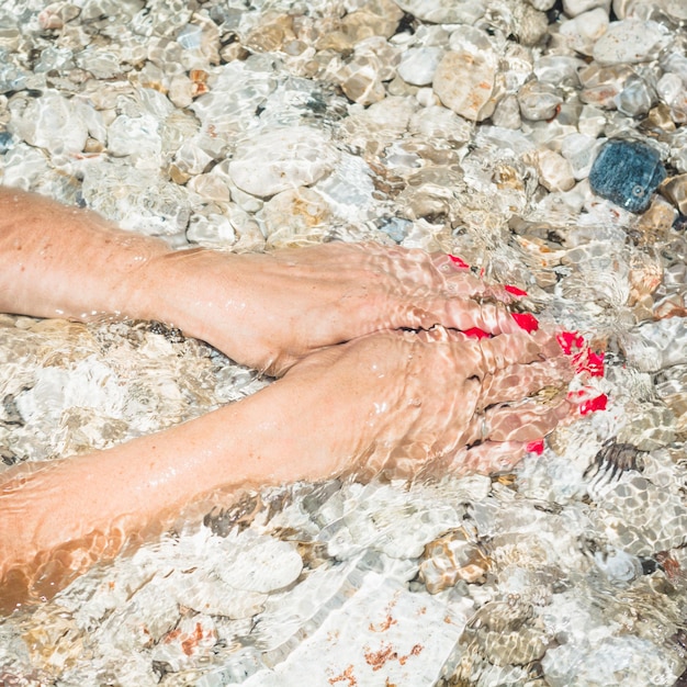 Beautiful female hand in the clean sea water Eco spa concept