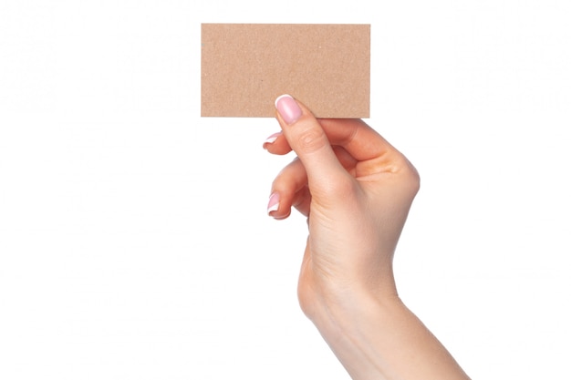 Beautiful female hand holding white business card on white