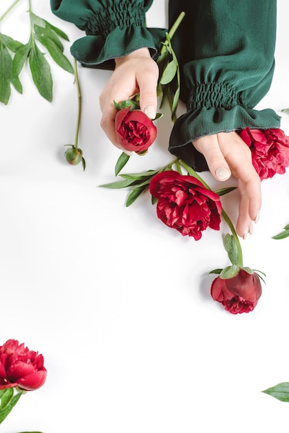 Beautiful female hand with red flowers on white 