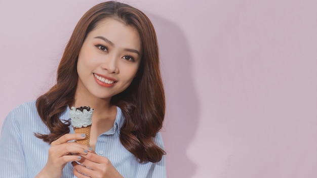 Beautiful female holding and eating ice cream on summer holidays