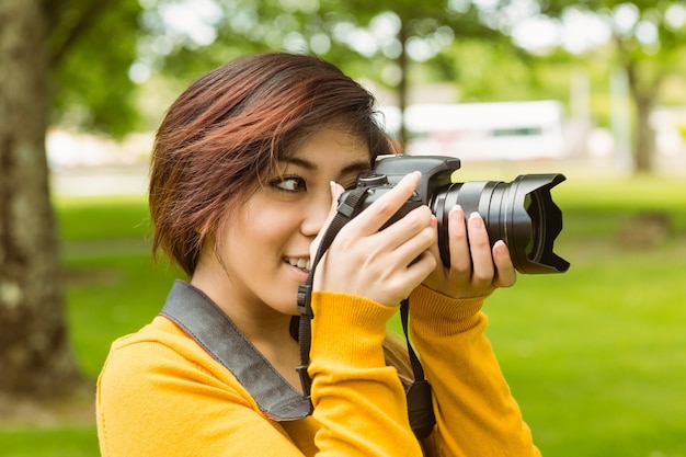 Beautiful female photographer at park