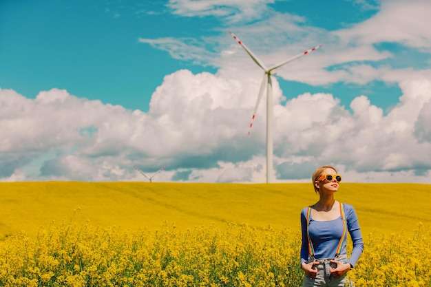 Beautiful female in rainbow LGBT suspenders for pants in rapeseed field