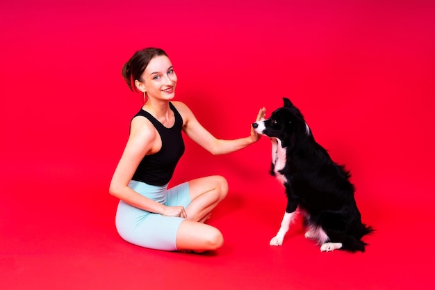 Beautiful female with border collie in studio yellow and red background