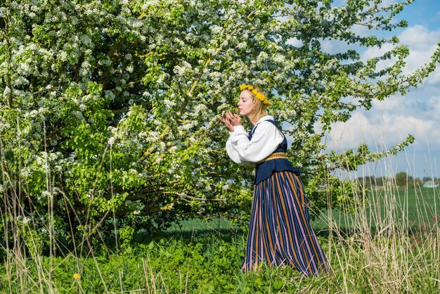 Beautiful feminime woman in national dress with white spring flowers