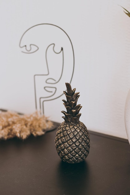 A beautiful figurine of a small black pineapple stands on the table as decor