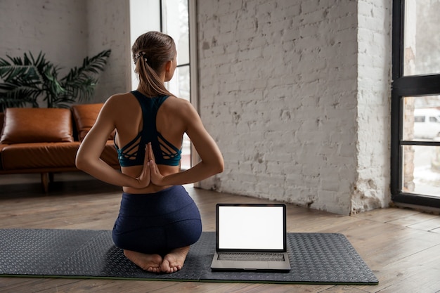 Photo beautiful fit woman yoga teacher conducting virtual yoga class at home on a video conference. . high quality photo