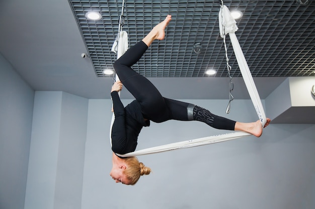 Beautiful fitness model on flying yoga hammock