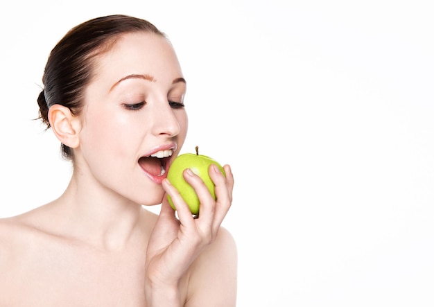 Beautiful fitness woman eating healthy apple