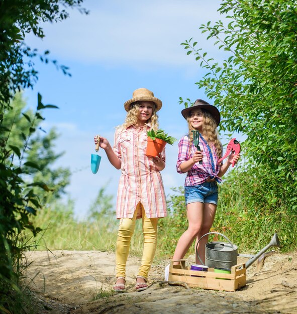 Beautiful florist at work ecology and environmental protection earth day summer family farm children hold gardening tools farming and agriculture spring country side girls farmer in village