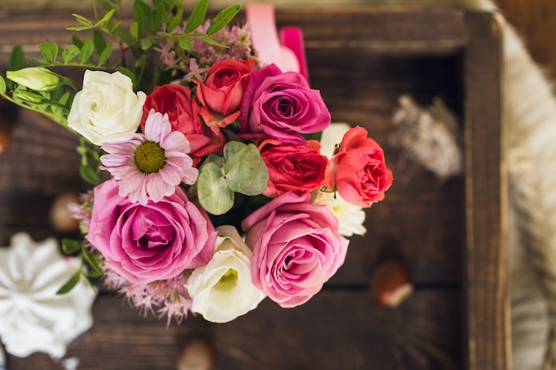 Beautiful flowers in cup on wooden