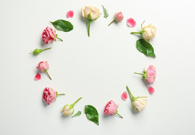 Beautiful flowers and green leaves as floral frame on white background