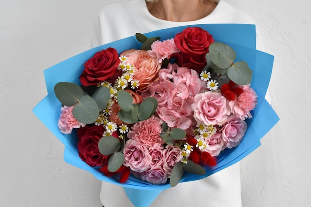 Beautiful flowers for holiday Woman with beautiful flowers in hands indoors background bouquet of flowers for flower shop