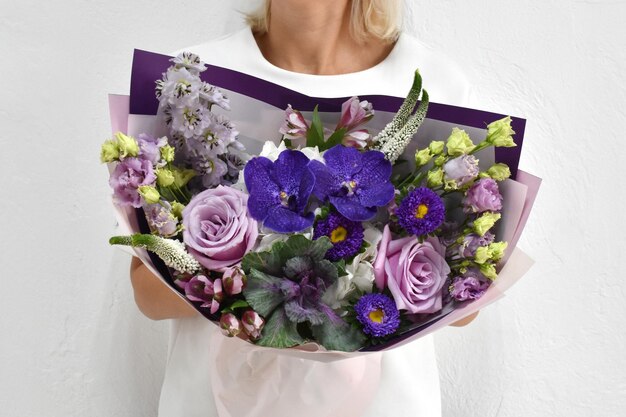 Beautiful flowers for holiday Woman with beautiful flowers in hands indoors background bouquet of flowers for flower shop