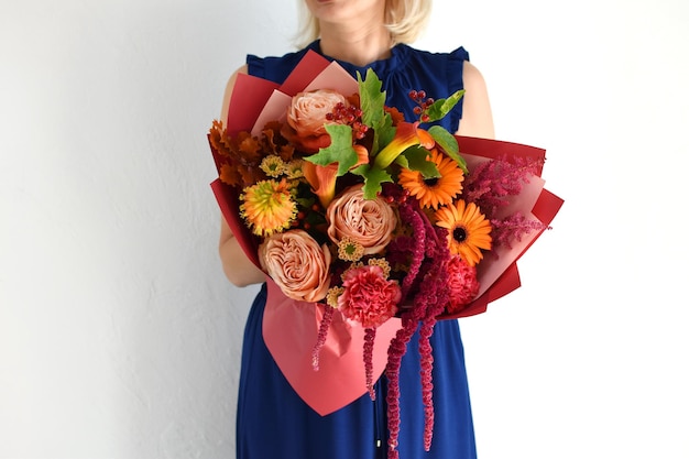 Beautiful flowers for holiday Woman with beautiful flowers in hands indoors background bouquet of flowers for flower shop