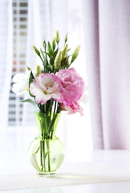 Beautiful flowers in vase with light from window