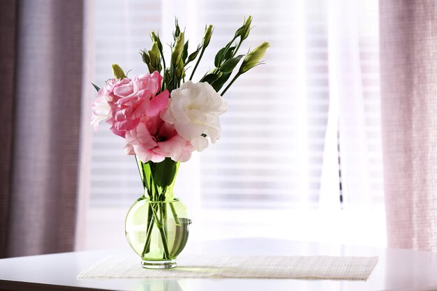 Beautiful flowers in vase with light from window