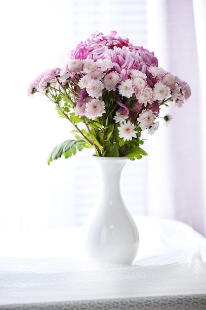 Beautiful flowers in vase with light from window