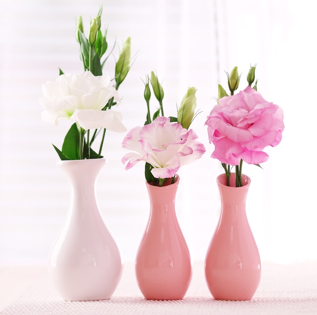 Beautiful flowers in vases with light from window