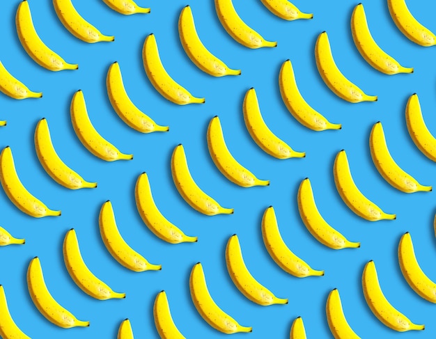 Beautiful fresh bananas lie on a blue background pattern Vitamins and fruits creative idea