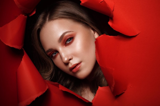 Beautiful fresh girl with perfect skin bright red makeup Beauty face Photo taken in the studio