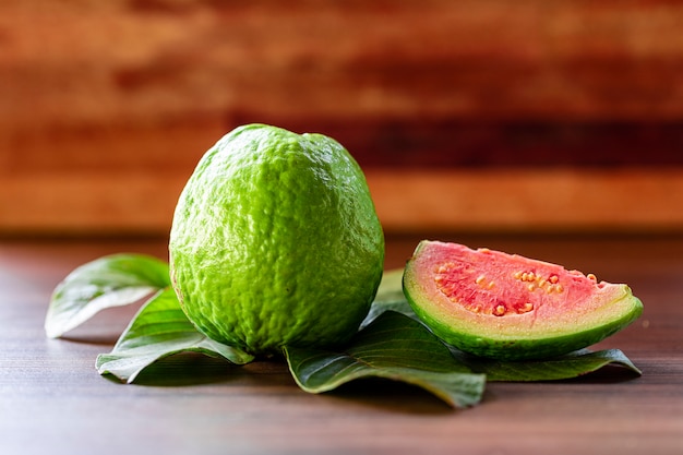 Beautiful fresh red guava, autumn fruit on wooden rustic background.