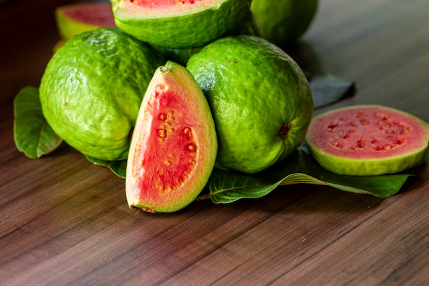 Beautiful fresh red guava, autumn fruit on wooden rustic table