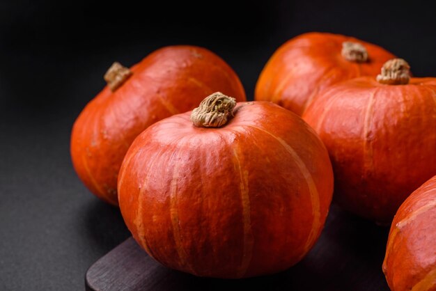 Beautiful fresh round pumpkins in orange color on a dark concrete background Preparing for the Halloween celebration