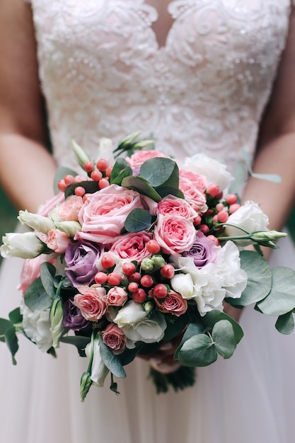 Beautiful fresh wedding bouquet in the hands of the bride