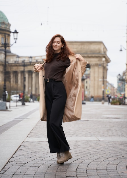 Beautiful funny naughty stylish fashionable happy girl dancing on streets of St. Petersburg city. 