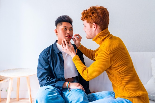 Beautiful gay couple doing makeup and having fun being romantic indoors at home lgbt concept real people