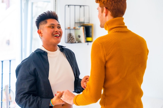 Beautiful gay couple having fun and dancing to music indoors at home lgbt concept