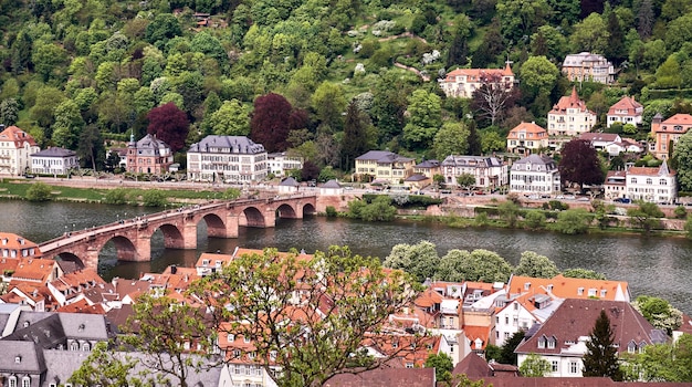 Beautiful Germany. Aerial view over Heidelberg town in Springtime. City center with tiled roofs, bridge over river Neckar and hills with Spring forest.