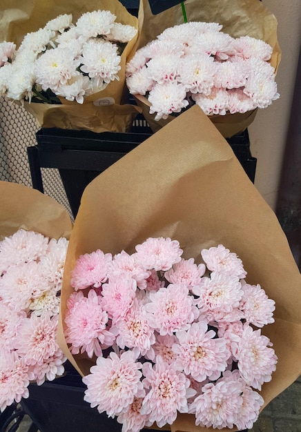 Beautiful gift bouquets of chrysanthemums in brown kraft paper on the counter of a flower shop vertical