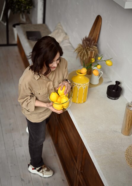 beautiful girl in a beige kitchen with yellow lemons Sicilian style italy