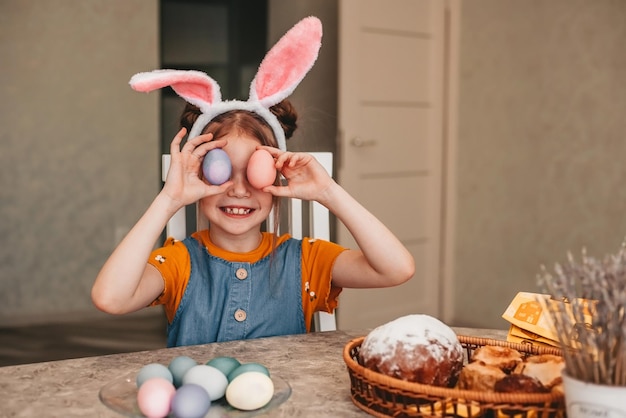 beautiful girl in bunny ears paint Easter eggs