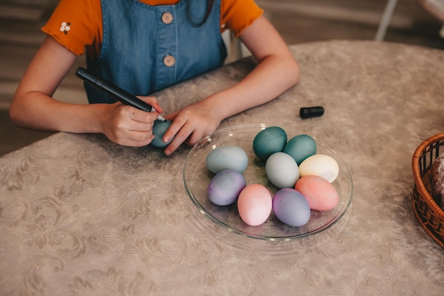 Beautiful girl in bunny ears paint easter eggs